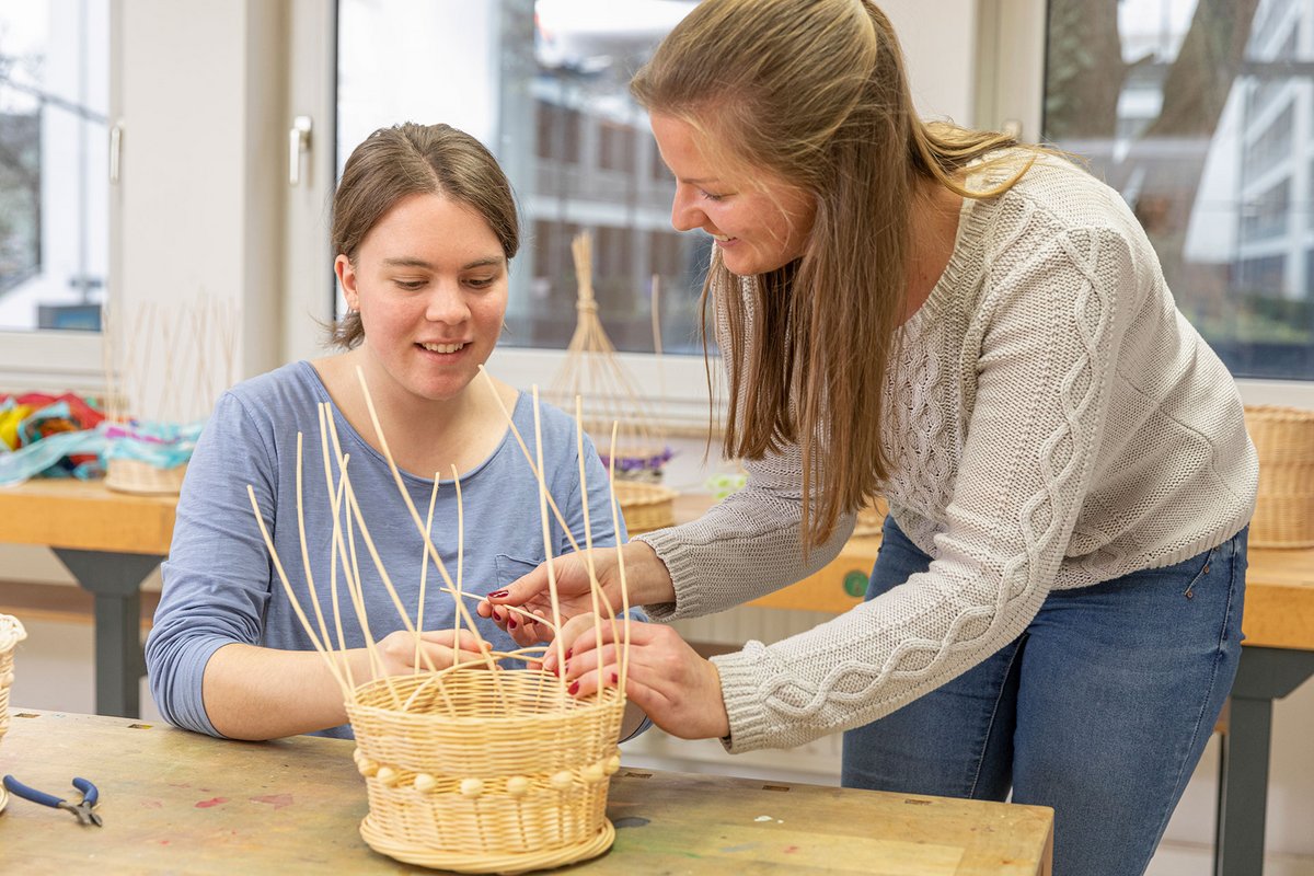 Unterricht Ergotherapie Schule Mainz - Schülerin und Dozentin beim Korbflechten