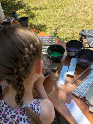 Stand ETS auf Sommerfest Person von hinten, die eine Seifenblasen-Aquarelltechnik ausführt