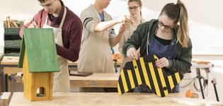 Zwei Auszubildende bei der Holzarbeit Ergotherapieausbildung