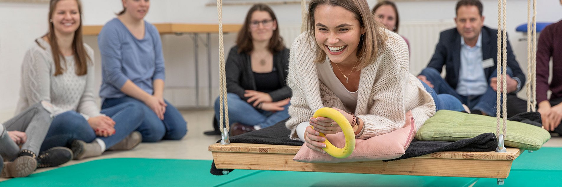Ergotherapieschülerin auf Therapieschaukel liegend